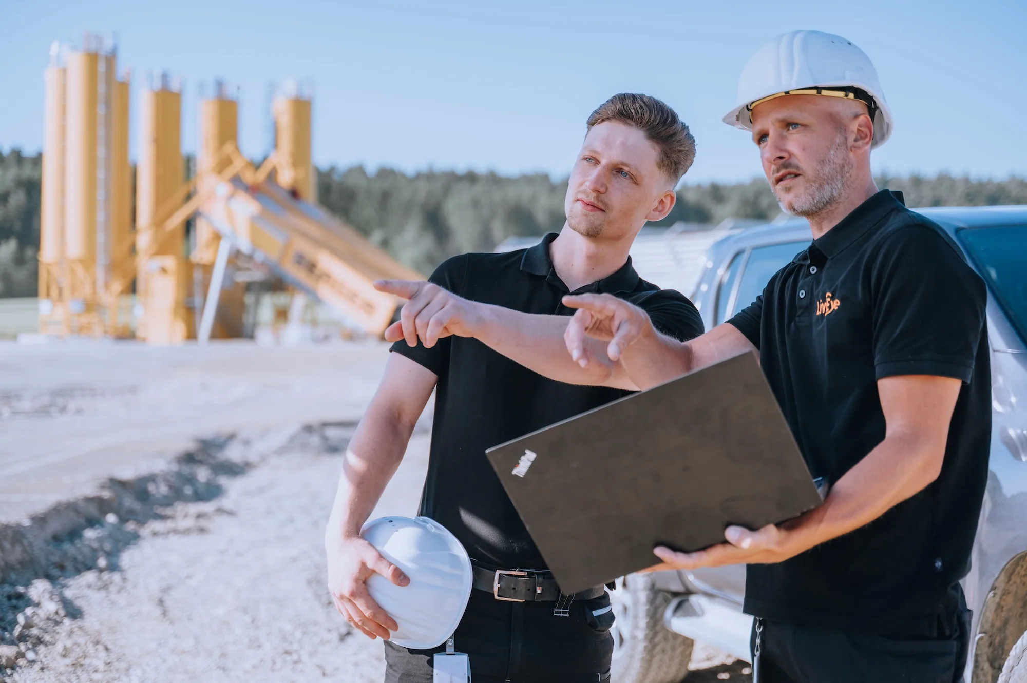 Zwei Männer auf einer Baustelle planen