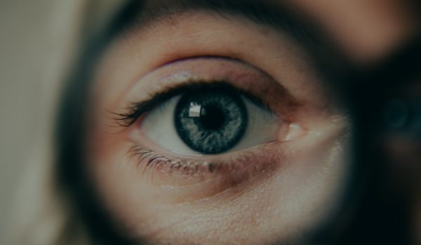 Ein Auge einer Frau, durch eine Brille herangezoomt